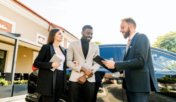 Young People business couple African man and Caucasian woman standing outdoors in a Car Rental